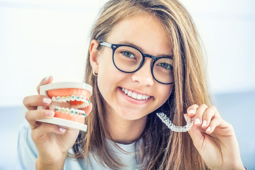 Mädchen vergleicht feste Zahnspange mit Invisalign Schiene